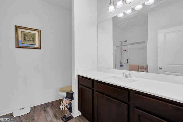 bathroom featuring toilet, a shower, wood-type flooring, and vanity