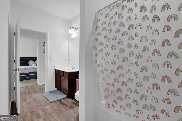 full bathroom featuring toilet, vanity, hardwood / wood-style floors, and shower / bath combination with curtain