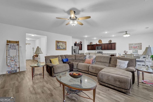 living room with ceiling fan and light hardwood / wood-style floors