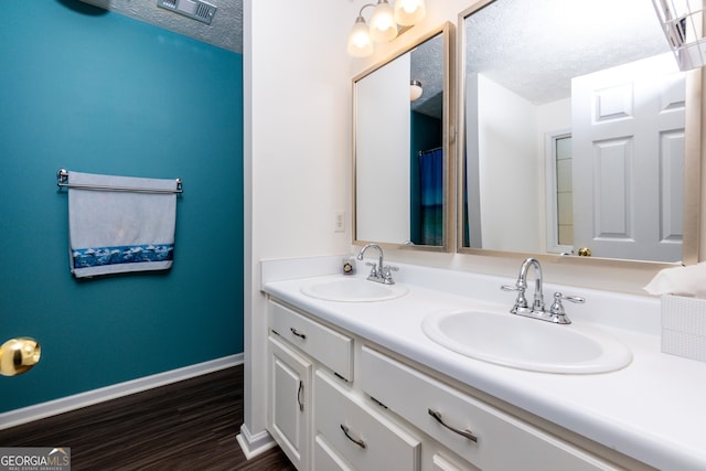 bathroom with vanity, hardwood / wood-style floors, and a textured ceiling