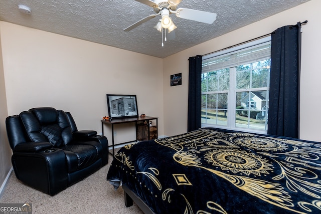 carpeted bedroom featuring ceiling fan and a textured ceiling