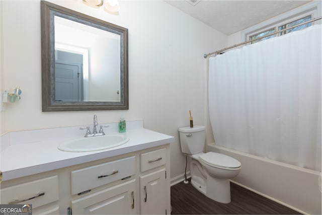 full bathroom with hardwood / wood-style floors, shower / bath combination with curtain, a textured ceiling, toilet, and vanity