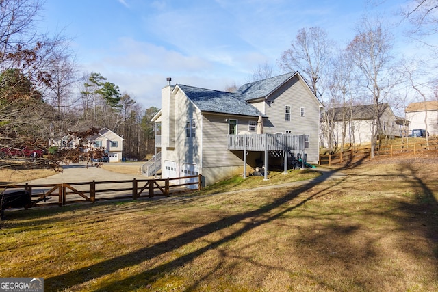 back of property featuring a lawn and a deck