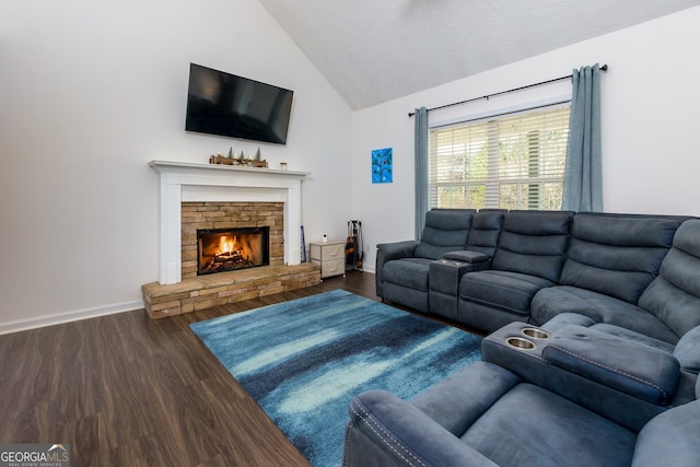 living room featuring a stone fireplace, hardwood / wood-style floors, and vaulted ceiling