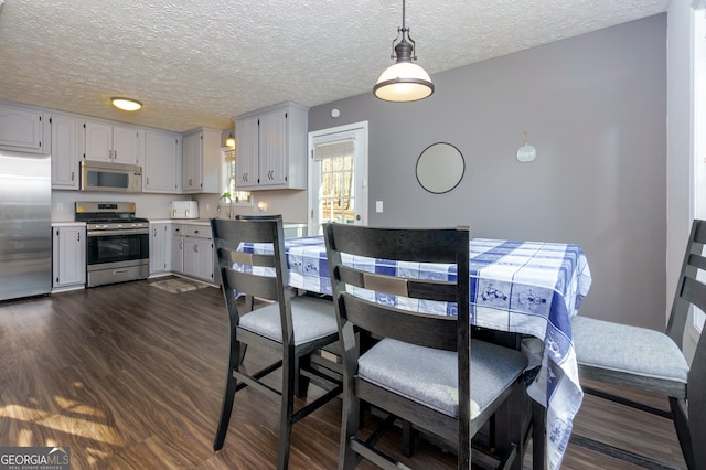 dining area with dark hardwood / wood-style floors and a textured ceiling