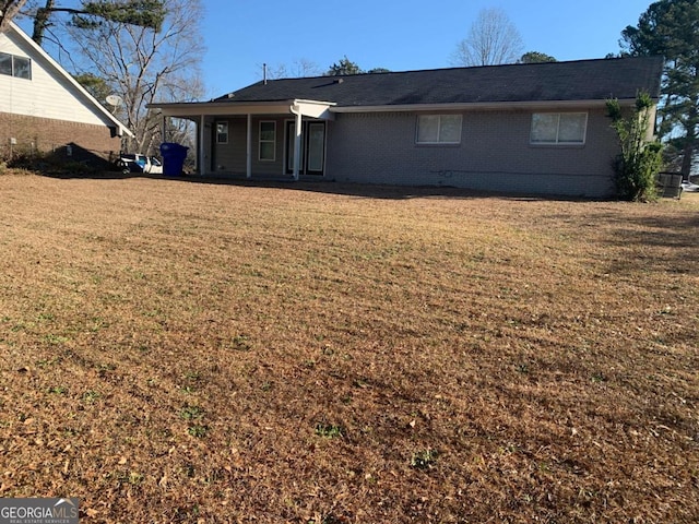 back of property with a lawn