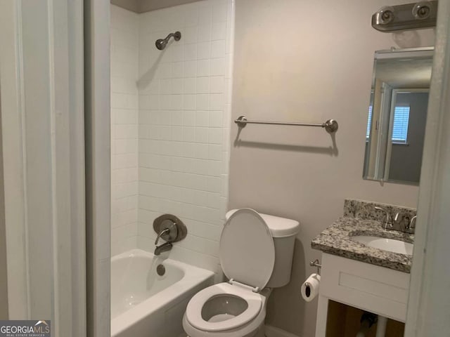 full bathroom featuring vanity, tiled shower / bath combo, and toilet