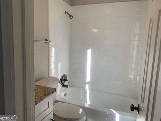 full bathroom featuring vanity, tiled shower / bath combo, and toilet