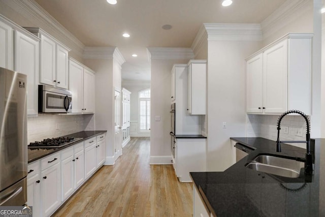 kitchen with decorative backsplash, sink, white cabinets, and appliances with stainless steel finishes