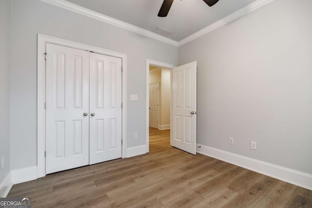 unfurnished bedroom with ceiling fan, a closet, crown molding, and light hardwood / wood-style floors