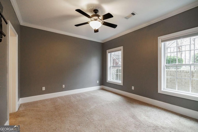 spare room with ceiling fan, light colored carpet, and ornamental molding