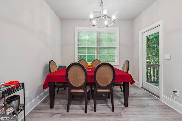 dining room with light hardwood / wood-style flooring and an inviting chandelier