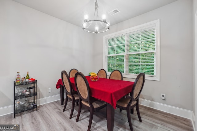 dining room with wood-type flooring and a notable chandelier