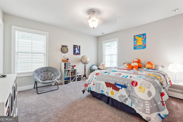 carpeted bedroom with multiple windows and ceiling fan