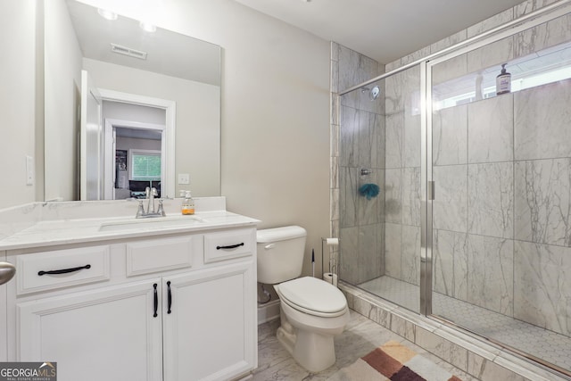 bathroom featuring vanity, toilet, and a shower with shower door