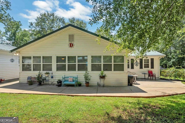 back of house featuring a patio area and a lawn