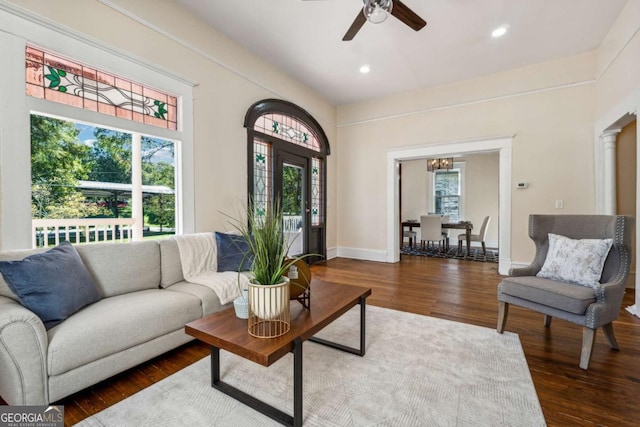 living room with decorative columns, a wealth of natural light, ceiling fan, and hardwood / wood-style flooring