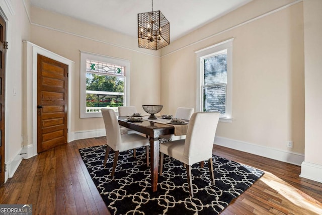 dining area featuring a wealth of natural light, dark wood-type flooring, and a notable chandelier