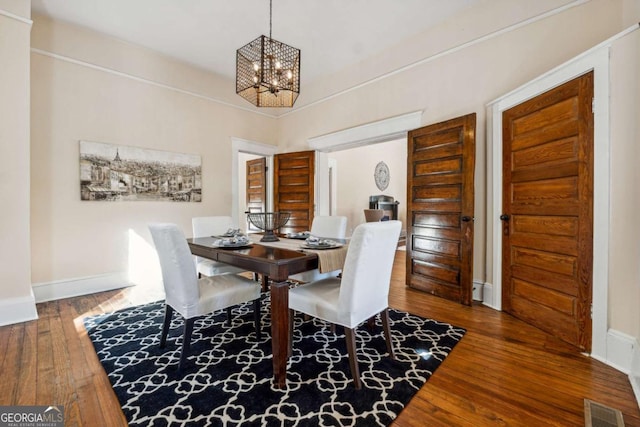 dining room with hardwood / wood-style flooring and an inviting chandelier