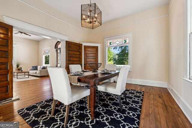 dining space with hardwood / wood-style floors, a notable chandelier, and a healthy amount of sunlight