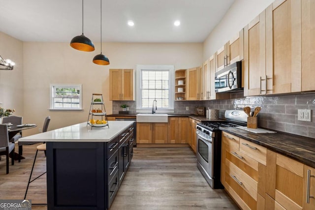 kitchen with decorative backsplash, appliances with stainless steel finishes, decorative light fixtures, plenty of natural light, and a breakfast bar area