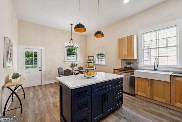 kitchen featuring dishwasher, sink, hanging light fixtures, an inviting chandelier, and light wood-type flooring