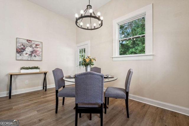 dining room with dark hardwood / wood-style floors and an inviting chandelier