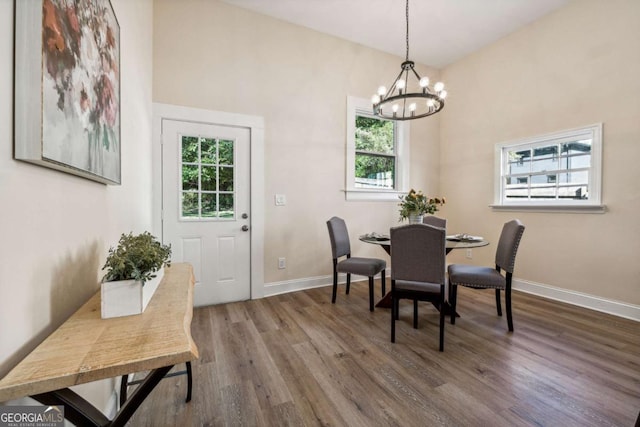 dining room with plenty of natural light, hardwood / wood-style floors, and a notable chandelier