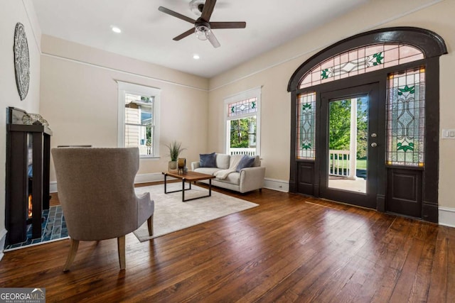 interior space featuring a wealth of natural light, ceiling fan, and dark wood-type flooring