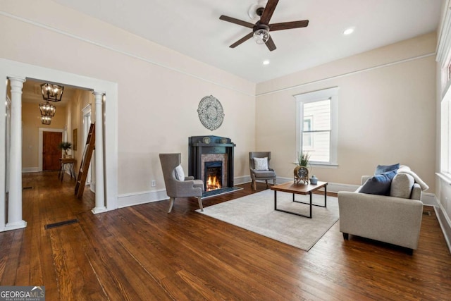 living room featuring dark hardwood / wood-style floors, ornate columns, and ceiling fan