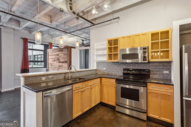 kitchen featuring kitchen peninsula, hanging light fixtures, stainless steel appliances, and sink