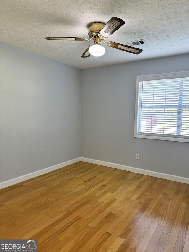 spare room featuring ceiling fan, a textured ceiling, and hardwood / wood-style flooring