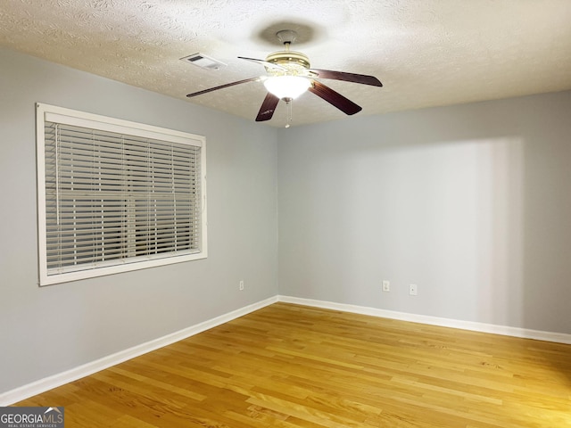 empty room with wood-type flooring, a textured ceiling, and ceiling fan