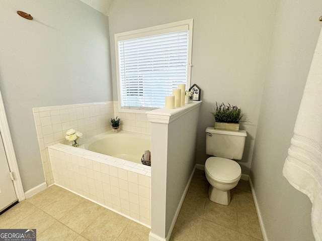 bathroom with tile patterned flooring, toilet, lofted ceiling, and tiled tub