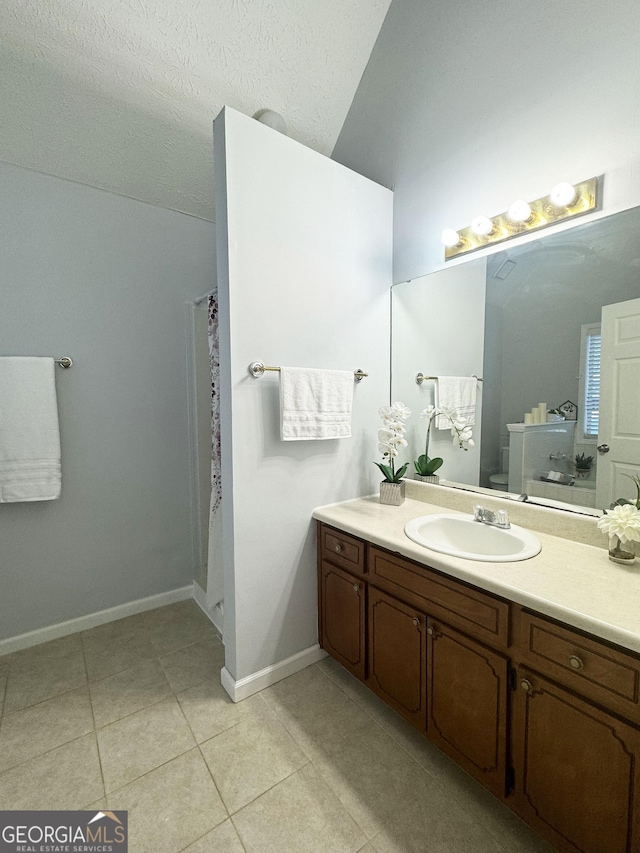 bathroom with a shower with shower curtain, tile patterned floors, vanity, a textured ceiling, and toilet