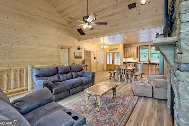 living room with ceiling fan, wood ceiling, light hardwood / wood-style floors, and wooden walls