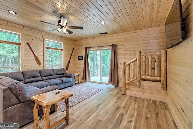 living room with light hardwood / wood-style floors, ceiling fan, wood walls, and wood ceiling