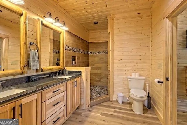 bathroom with toilet, hardwood / wood-style flooring, wooden walls, wooden ceiling, and vanity