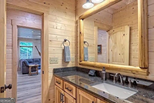 bathroom featuring vanity, hardwood / wood-style flooring, and wooden walls