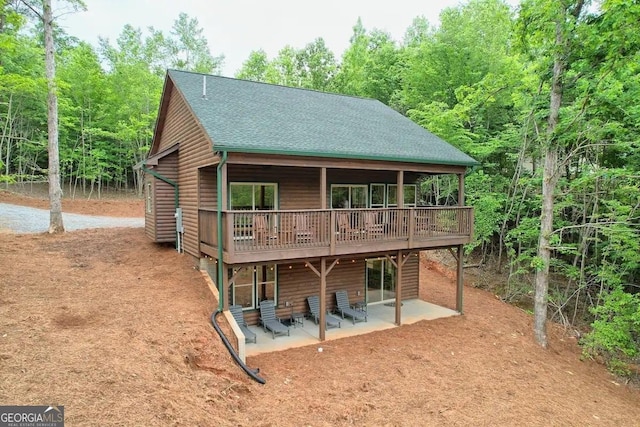 back of house with a deck and a patio