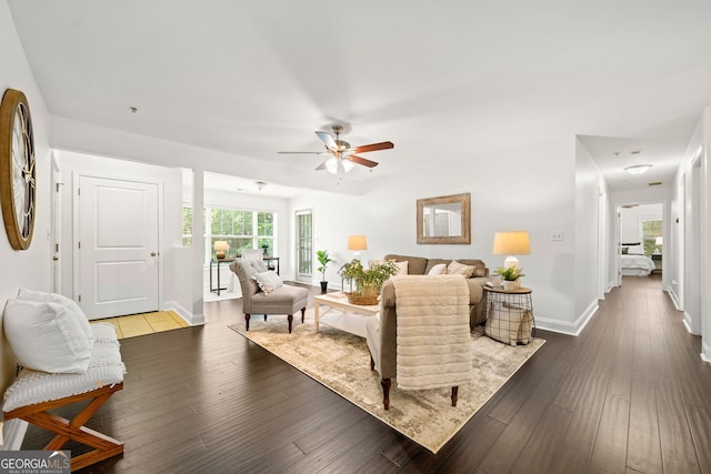 living room with ceiling fan and dark wood-type flooring