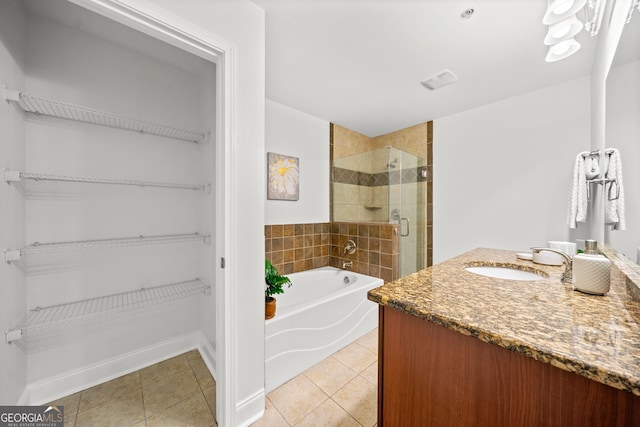 bathroom featuring shower with separate bathtub, vanity, and tile patterned floors