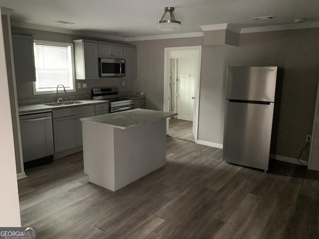 kitchen with gray cabinetry, a center island, sink, dark hardwood / wood-style floors, and stainless steel appliances