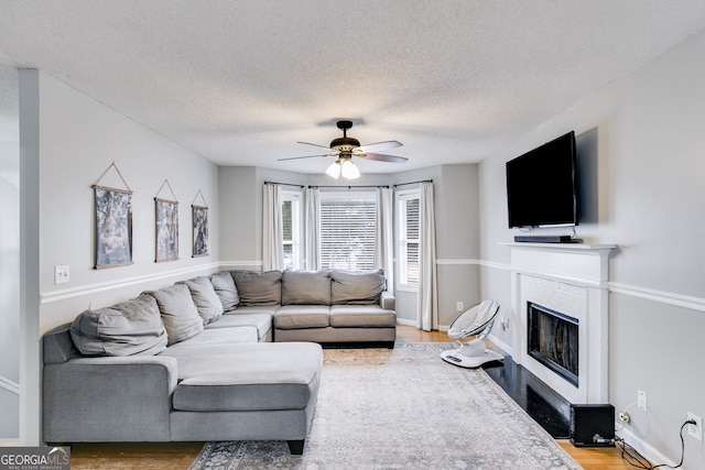 living room featuring a textured ceiling, hardwood / wood-style flooring, and ceiling fan