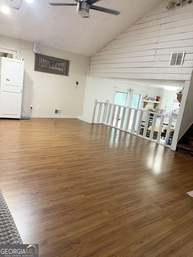 unfurnished living room featuring ceiling fan, hardwood / wood-style floors, and lofted ceiling