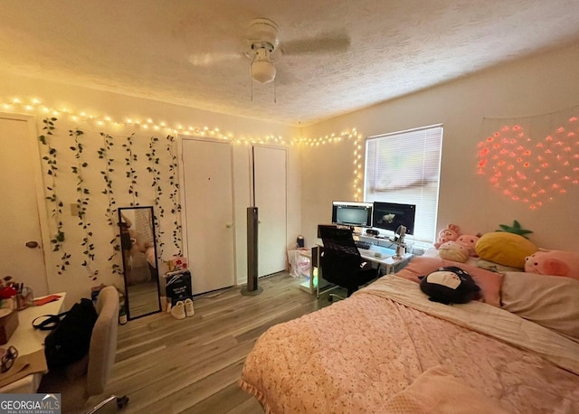 bedroom featuring wood-type flooring, a textured ceiling, and ceiling fan