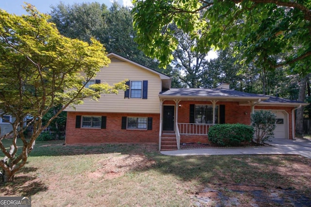 split level home with covered porch, a garage, and a front lawn