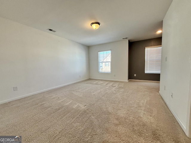 spare room featuring light carpet