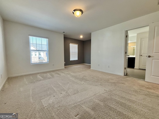 unfurnished room featuring light carpet