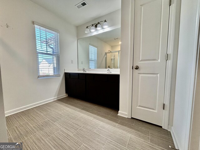 bathroom featuring vanity and a shower with door